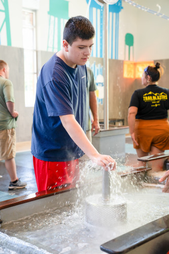 A guest playing the Water Amazements exhibit at the Scott Family Amazeum.