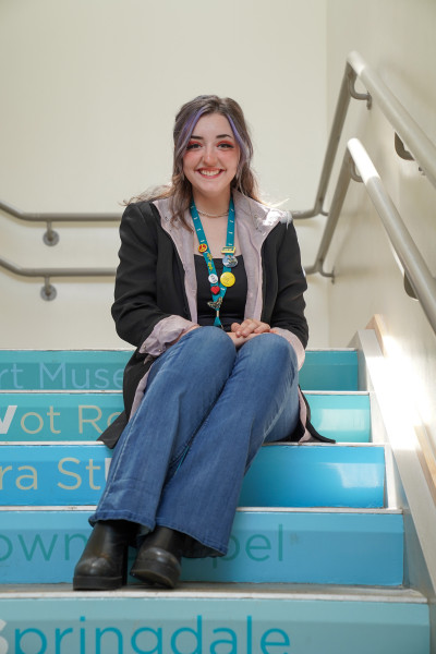 Savvanah Bollinger sitting on the Amazeum staircase.