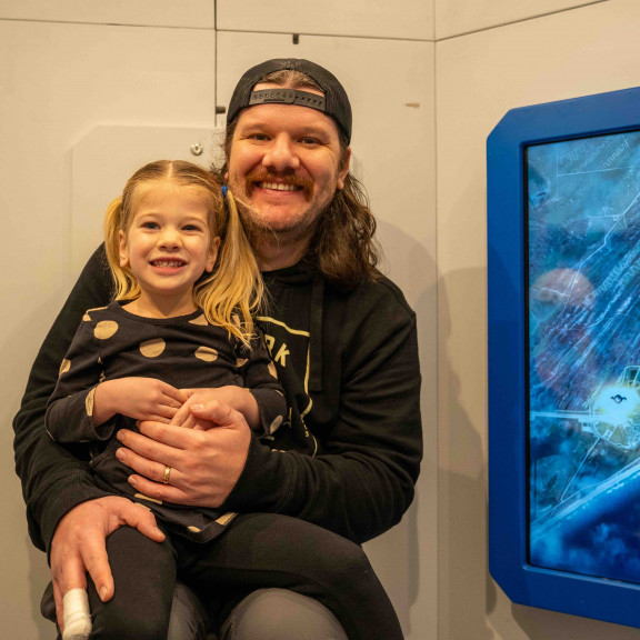 Dad with daughter smiling in space shuttle