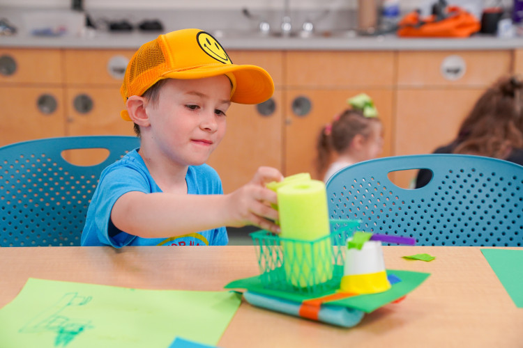 boy with yellow hat green boat